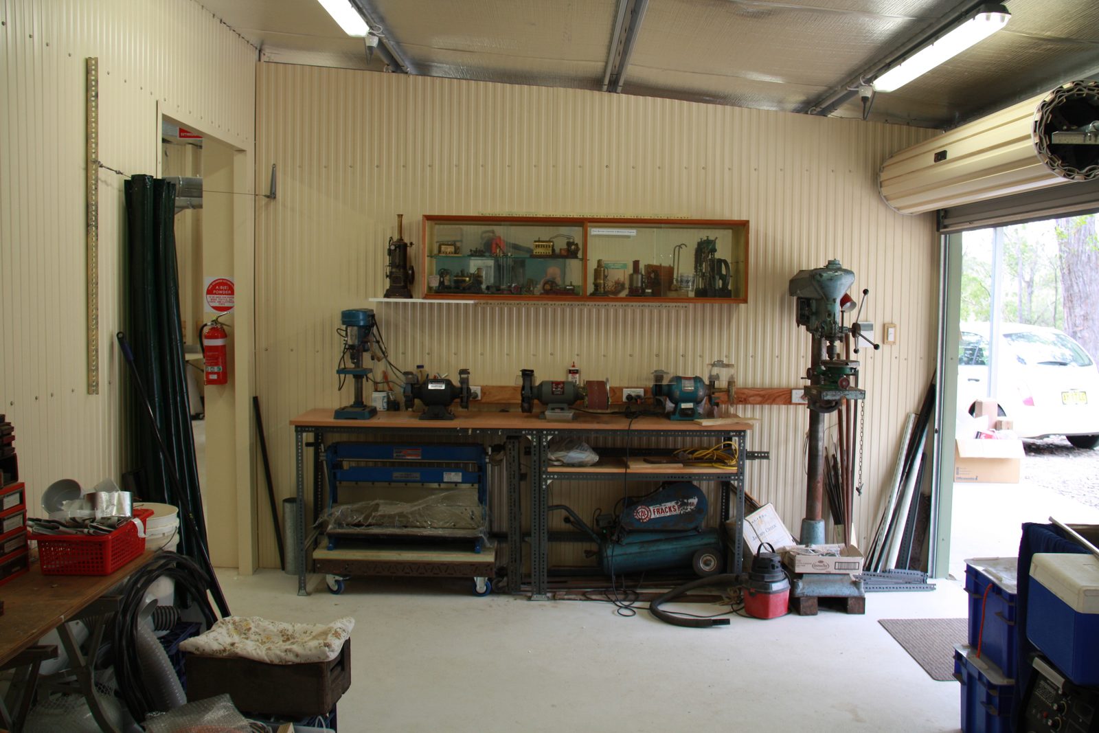 Finished workshop interior with tool bench and model steam engine display cabinet